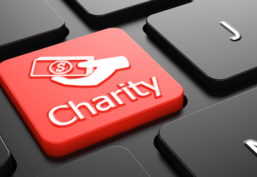 A red charity button on a black keyboard, representing income generation strategy ideas for charity organisations.