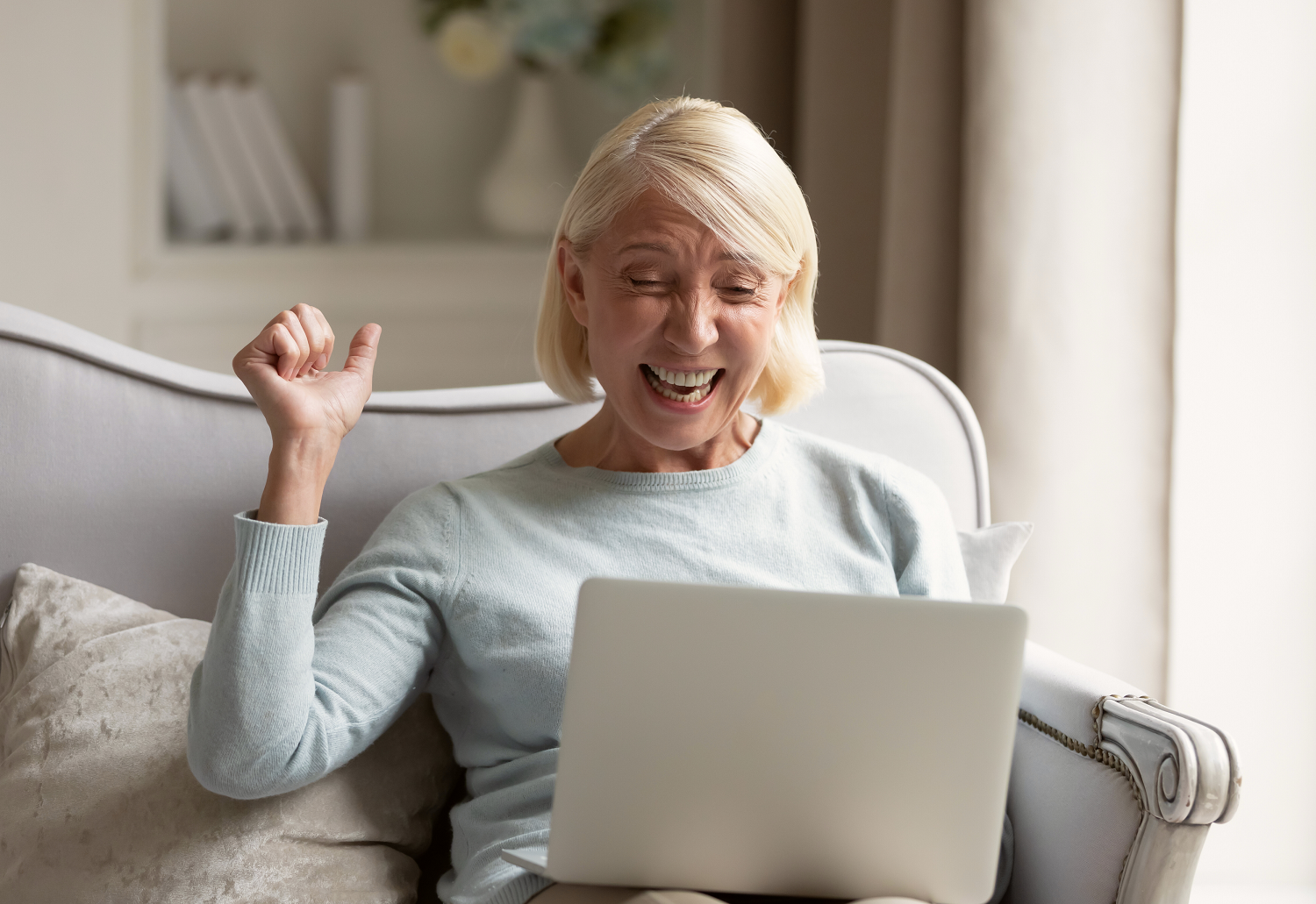 A senior woman celebrating as she wins an online lottery, representing prize-led charity fundraising trends.