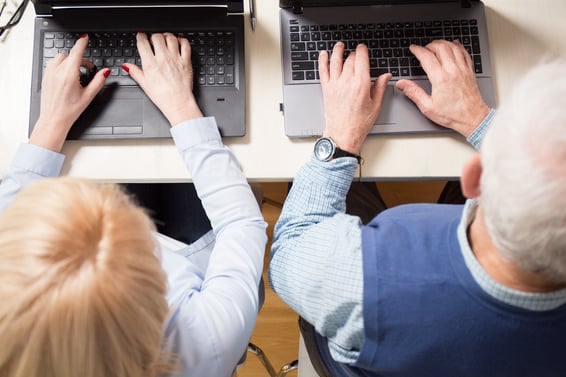 Close-up of older marriage working together on laptops