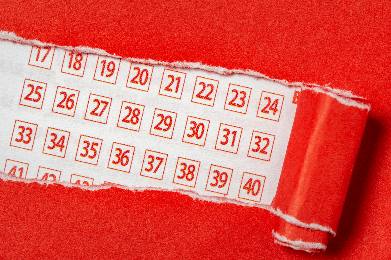 Red paper torn to reveal lottery ticket numbers, representing lottery service providers Woods Valldata