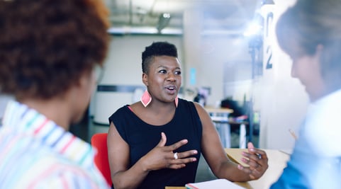 Unposed group of creative business people in an open concept office brainstorming their next project as a result of breaking down charity siloes