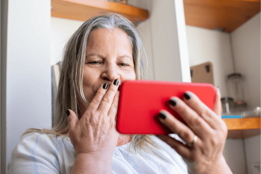 Woman at home holding a red phone, hand over mouth in amazement at winning the lottery, representing lottery services providers Woods Valldata-1