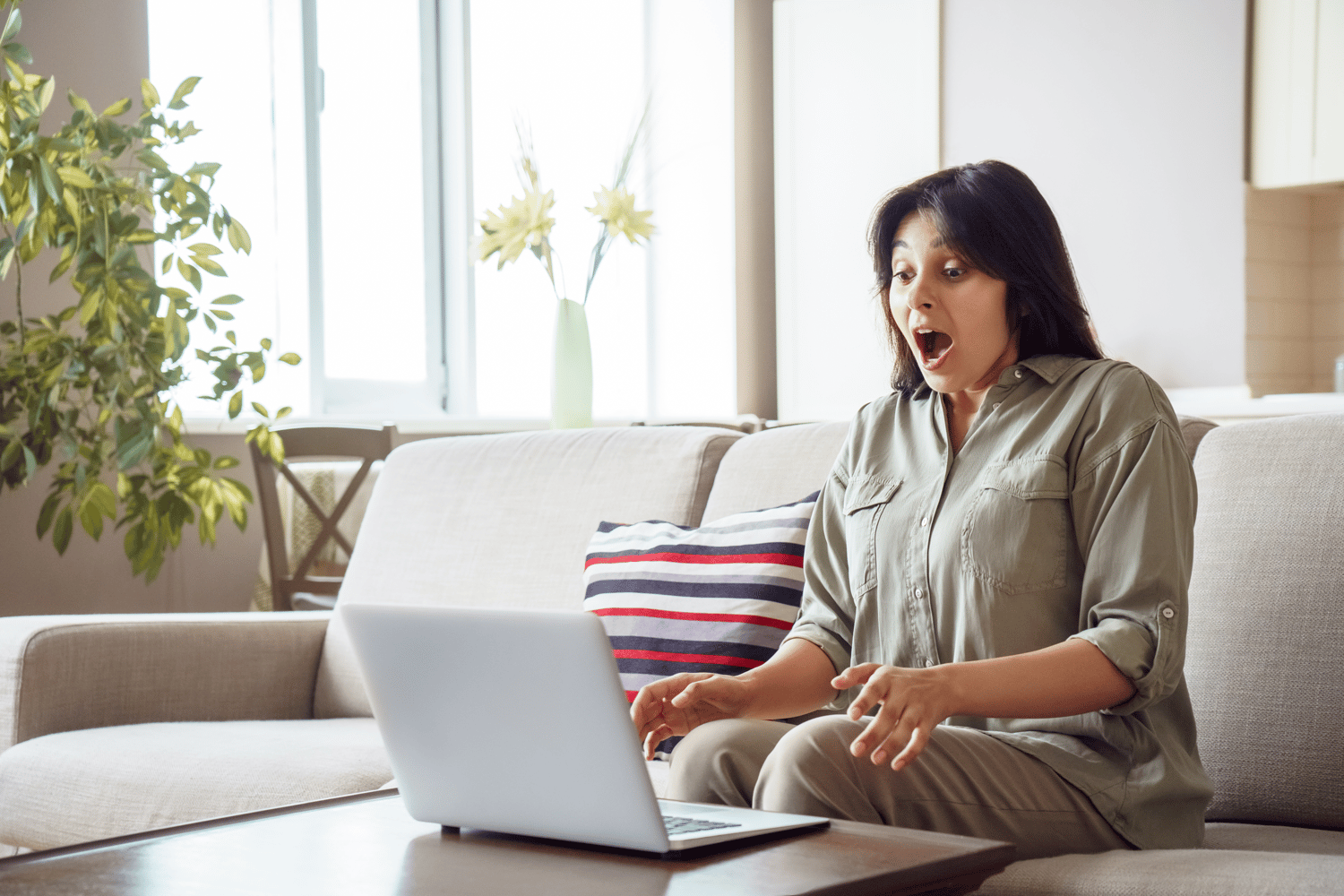 Woman expressing amazement at winning the lottery on her laptop, representing  representing lottery service providers Woods Valldata