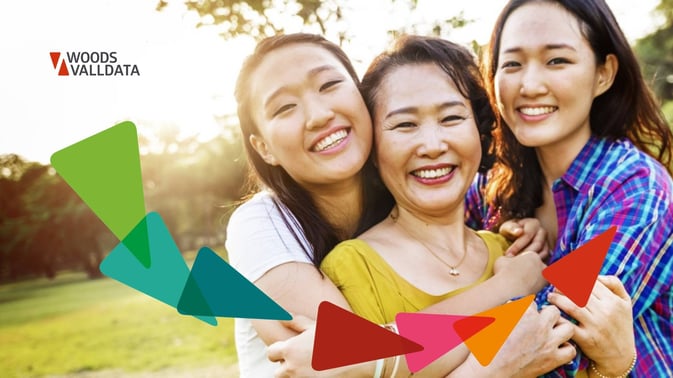asian mother and daughters embracing and smiling in a park on a summers day WV Brand
