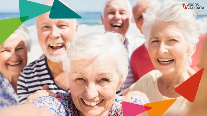 group of older men and women on a beach smiling and taking a selfie WV Branded